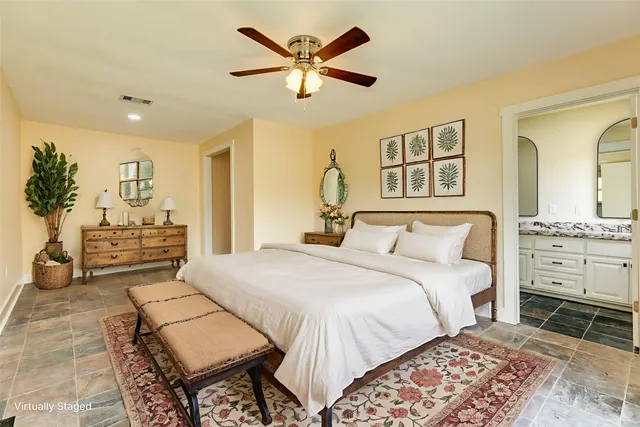 a bedroom with a large bed and a chandelier
