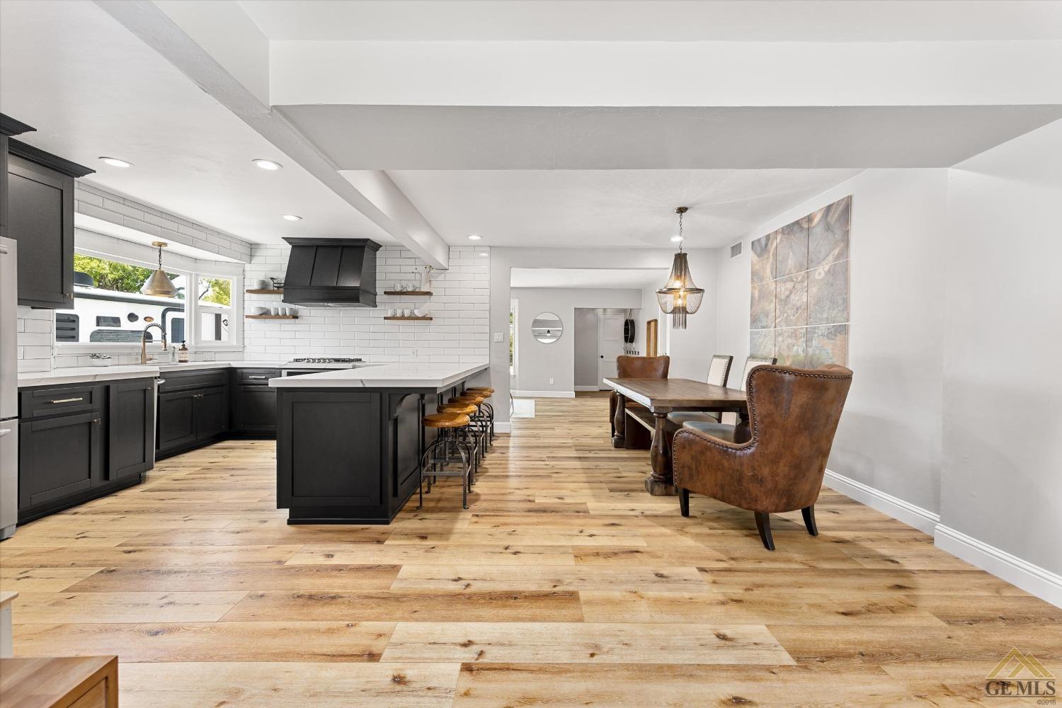 Undisclosed Address Bakersfield, CA 93305 - Photo 12 of 41 a living room with stainless steel appliances kitchen island granite countertop a sink dishwasher a dining table and chairs with wooden floor