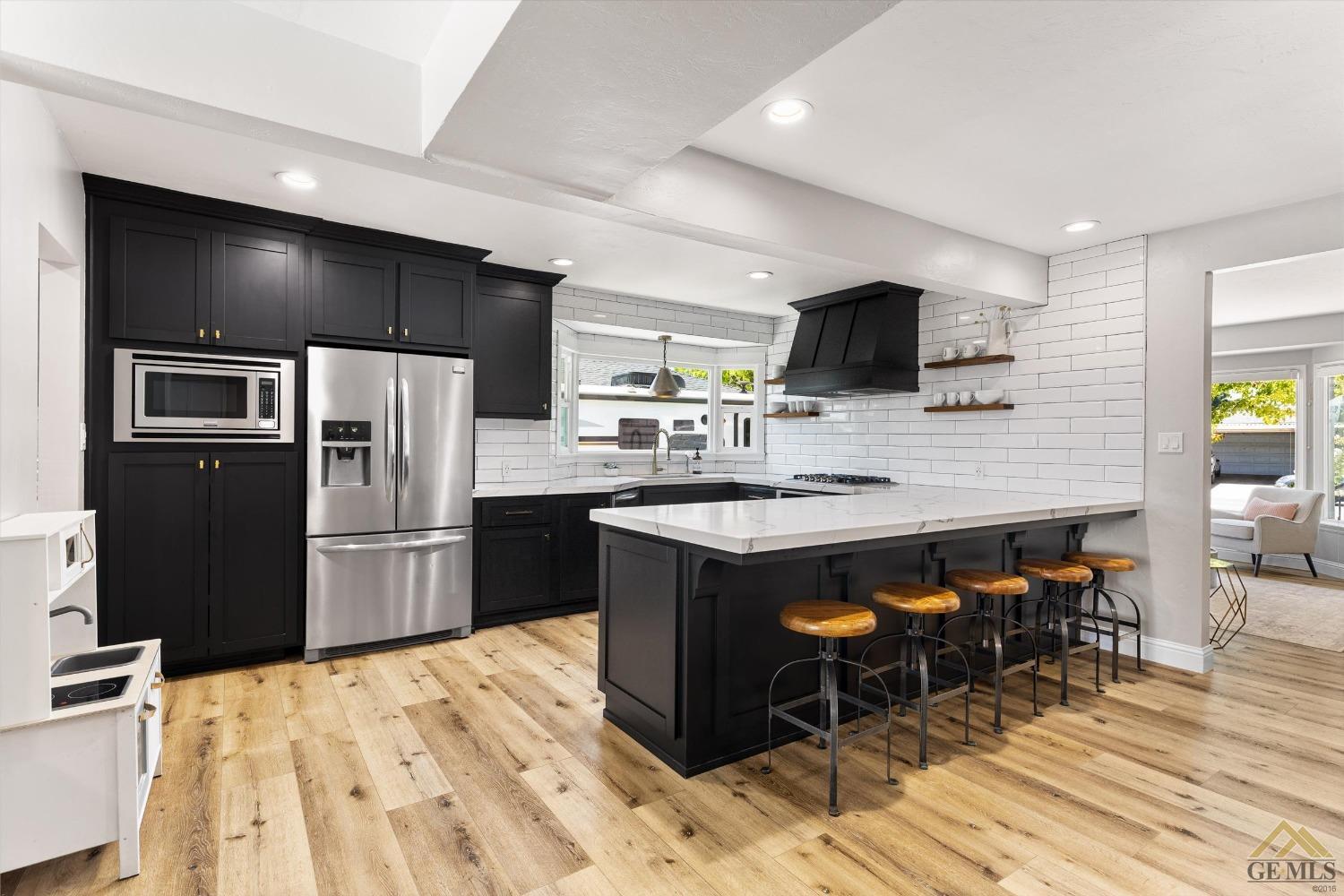 Undisclosed Address Bakersfield, CA 93305 - Photo 18 of 41 a kitchen with stainless steel appliances kitchen island granite countertop a refrigerator and a stove top oven