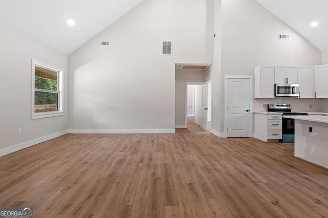 an empty room with wooden floor and window