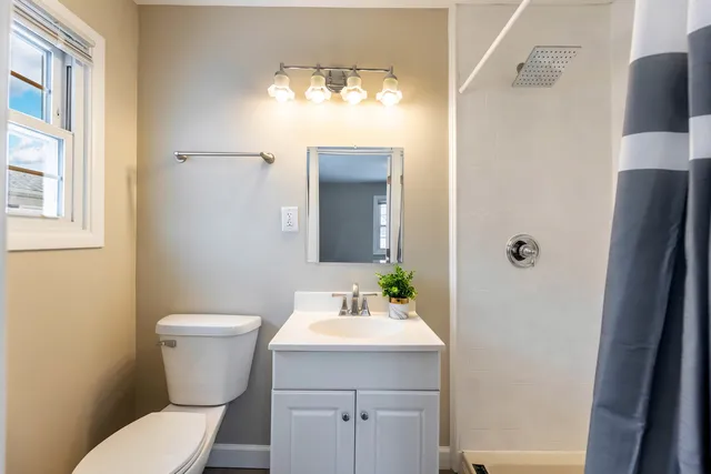 a bathroom with a toilet sink and mirror