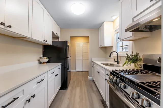 a kitchen with stainless steel appliances a sink stove and cabinets