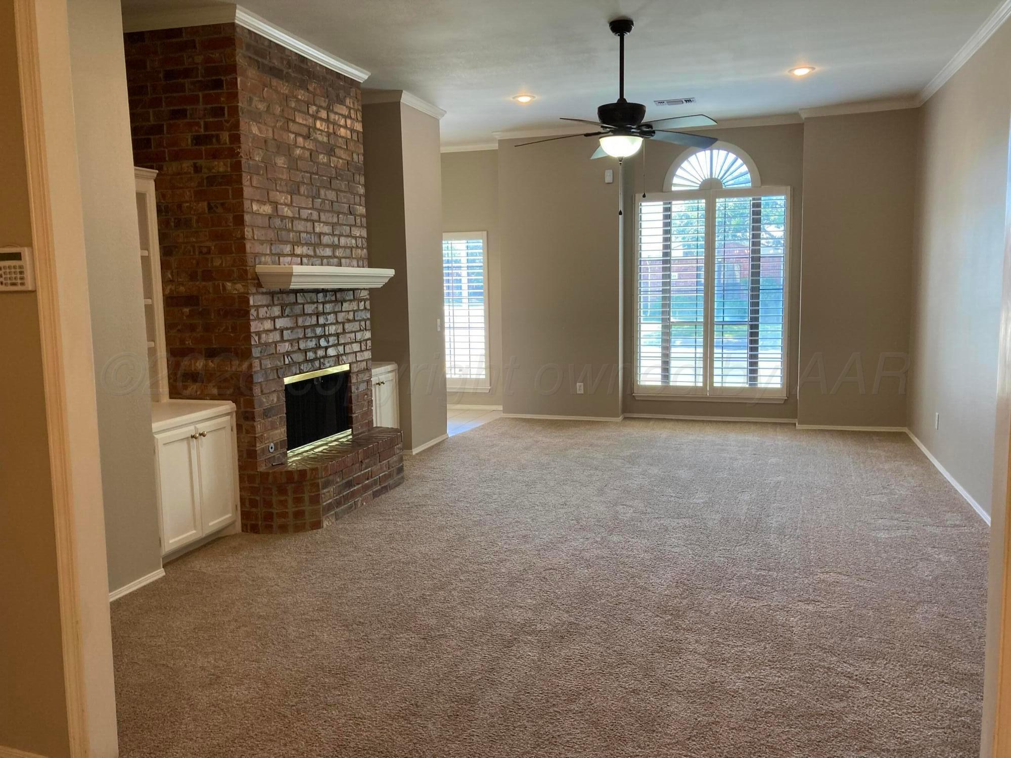 3509 West Point Drive Amarillo, TX 79121 - Photo 2 of 10 a view of an empty room with a fireplace and a window