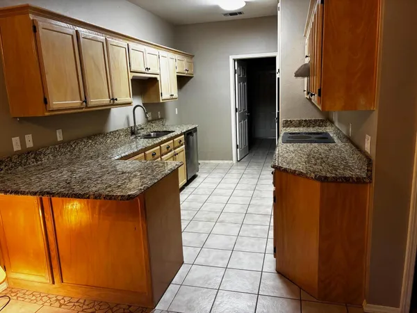 a kitchen with granite countertop a sink and a stove top oven