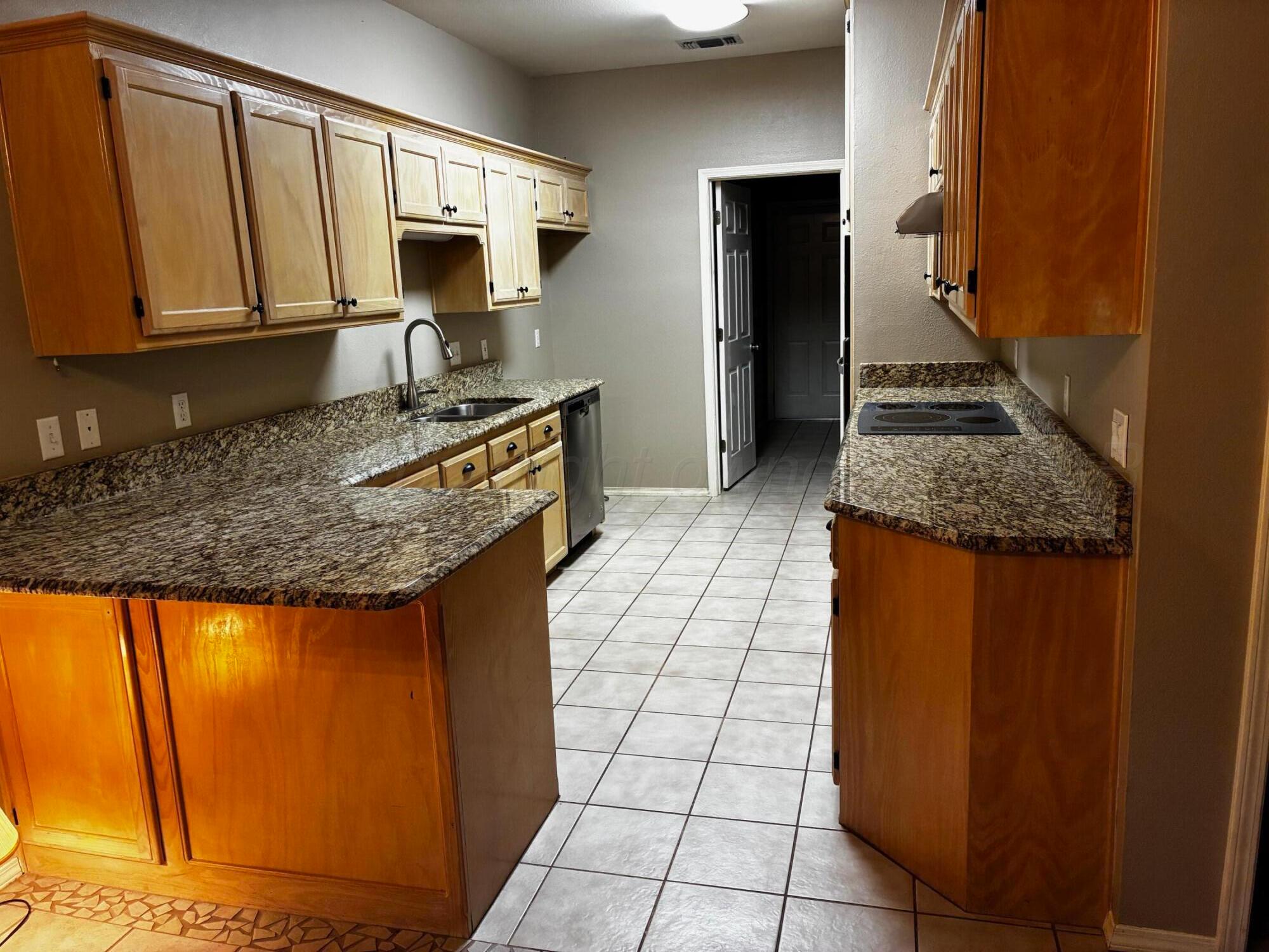 3509 West Point Drive Amarillo, TX 79121 - Photo 3 of 10 a kitchen with granite countertop a sink and a stove top oven
