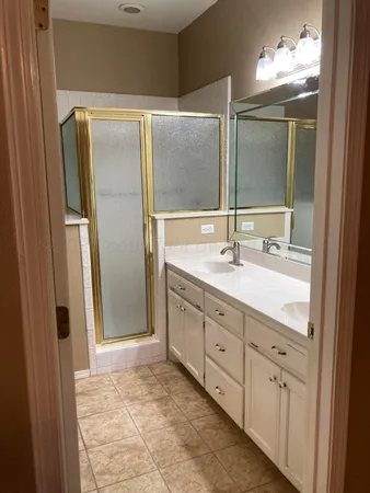 a bathroom with double vanity sink and a mirror