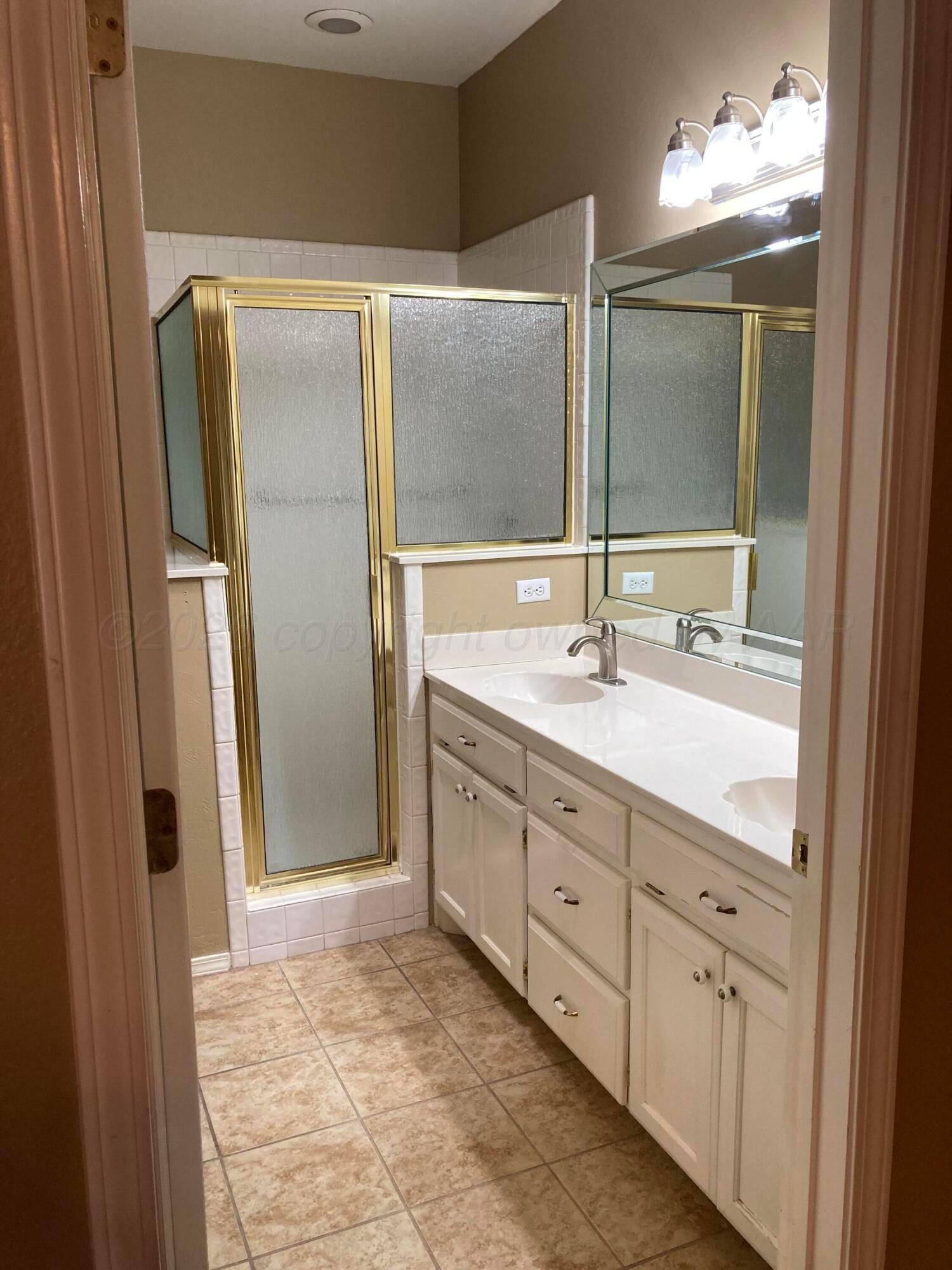 3509 West Point Drive Amarillo, TX 79121 - Photo 5 of 10 a bathroom with double vanity sink and a mirror