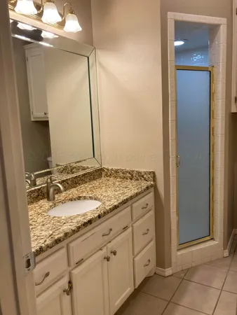 a bathroom with a granite countertop sink and a mirror