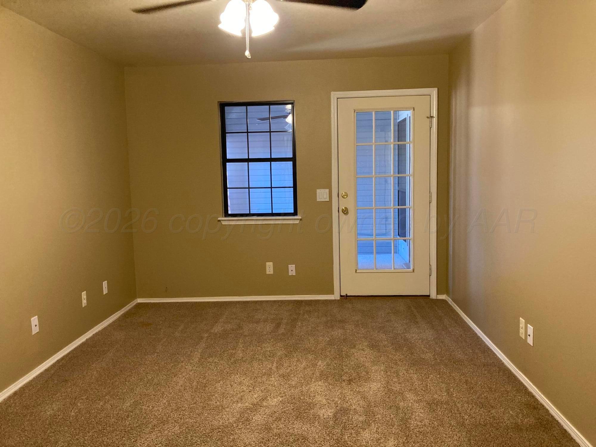 3509 West Point Drive Amarillo, TX 79121 - Photo 9 of 10 an empty room with windows and chandelier fan