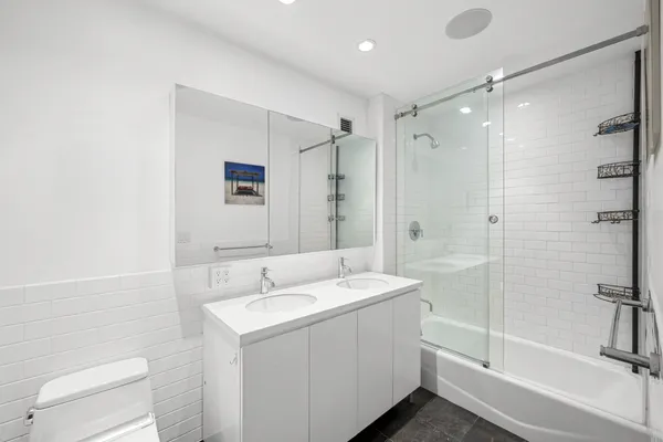 a bathroom with a sink a toilet and shower