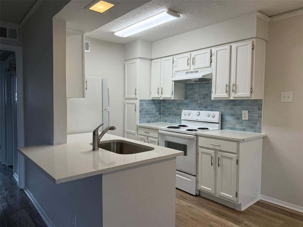 a kitchen with a sink stove and cabinets