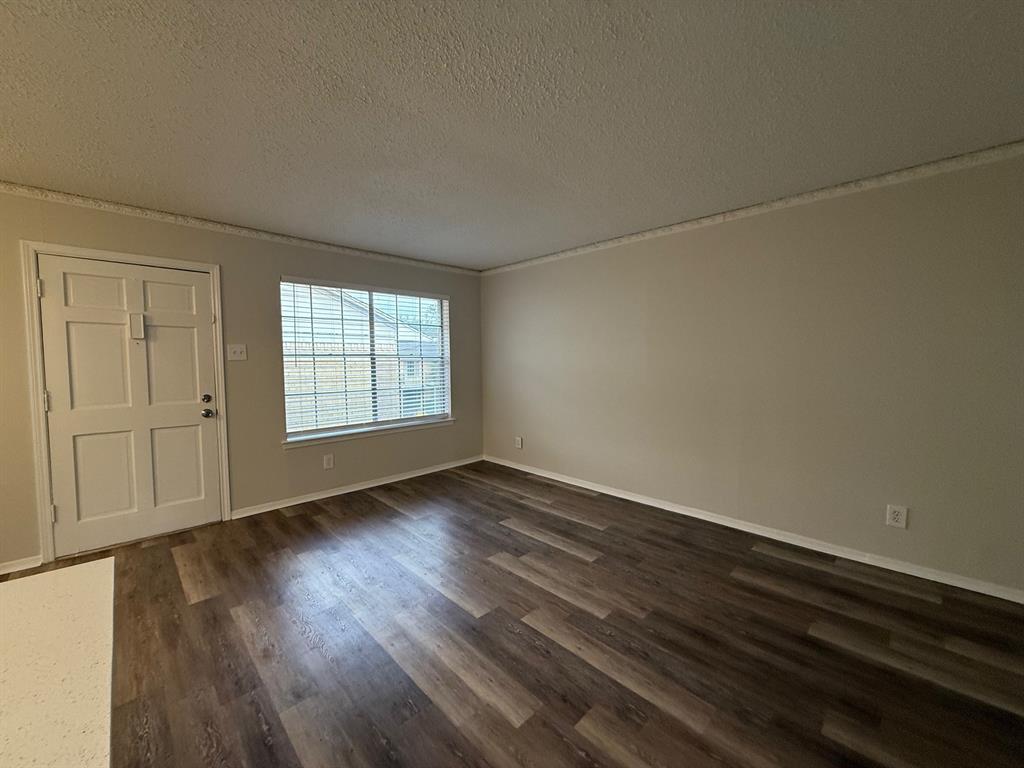3624 Parkridge Drive, Unit 214 Dallas, TX 75234 - Photo 2 of 10 an empty room with wooden floor and windows