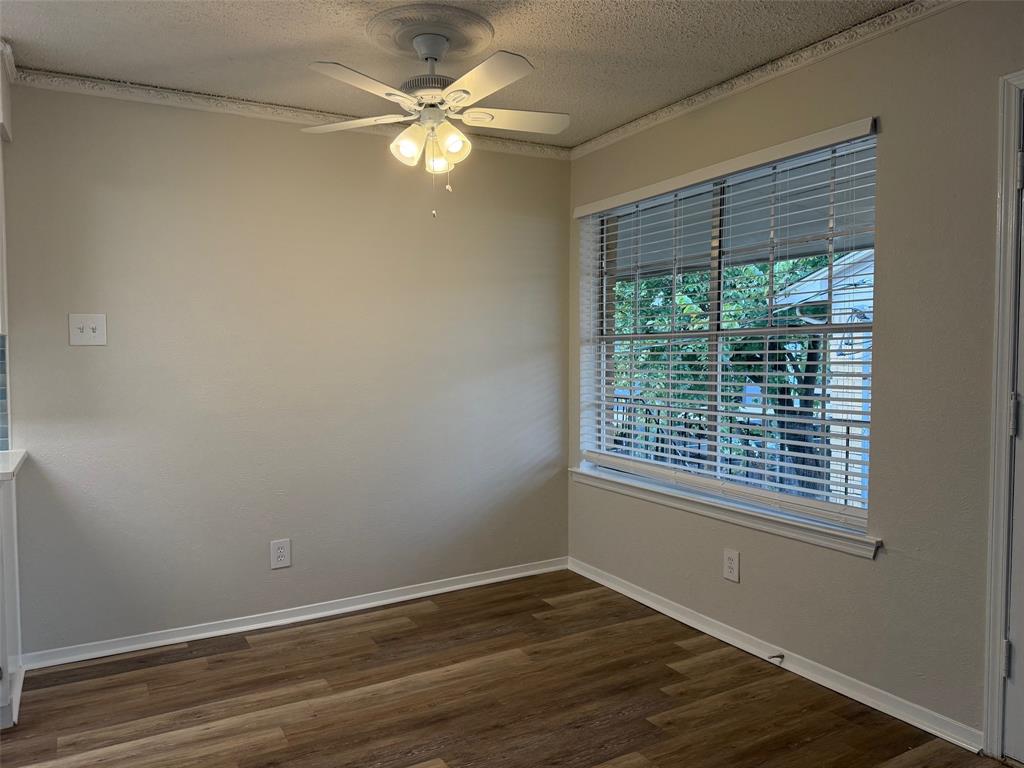 3624 Parkridge Drive, Unit 214 Dallas, TX 75234 - Photo 4 of 10 a view of an empty room with wooden floor and a window