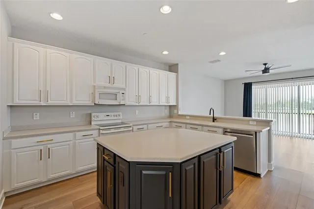 a kitchen with a sink a stove cabinets and wooden floor
