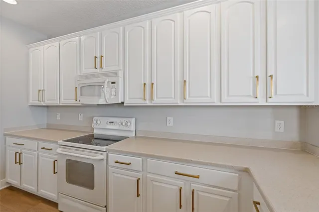 a kitchen with white cabinets and white appliances