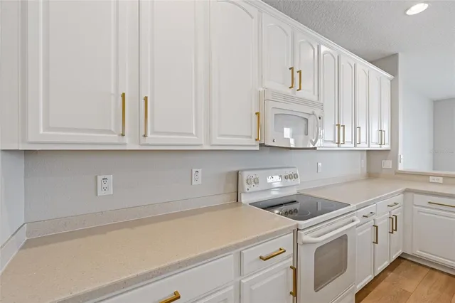 a kitchen with white cabinets and white appliances
