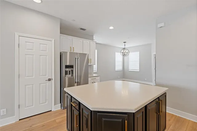 a kitchen with kitchen island a refrigerator stove and cabinets