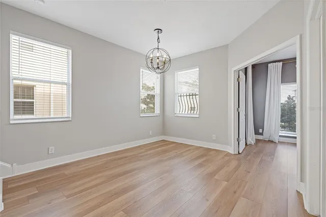 an empty room with wooden floor windows and exposed bricks