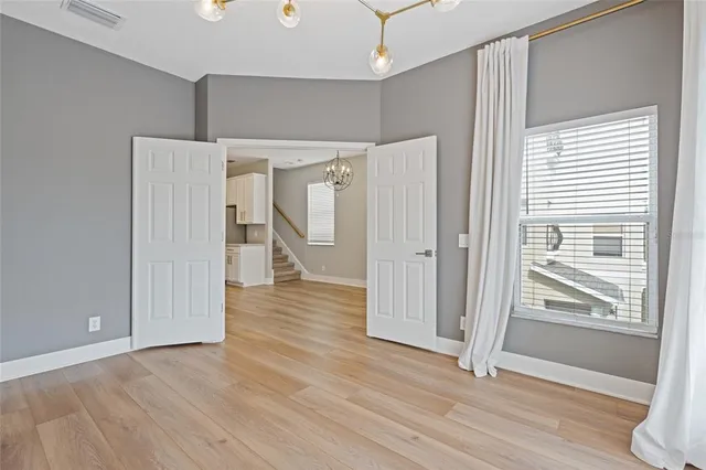 wooden floor in an empty room with a kitchen