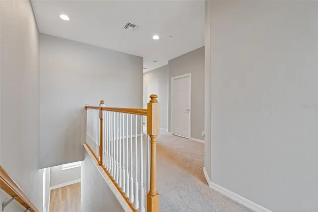 a view of a big room with wooden floor and windows
