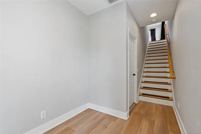 a view of a hallway with wooden floor and entryway