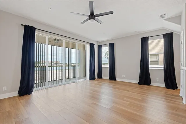 a view of a room with wooden floor and a ceiling fan