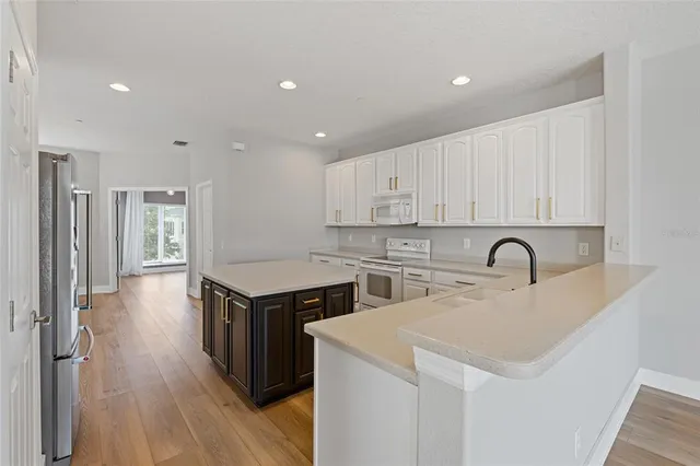 a kitchen with a sink cabinets and wooden floor