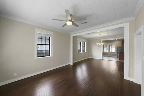 a view of an empty room with a window and wooden floor