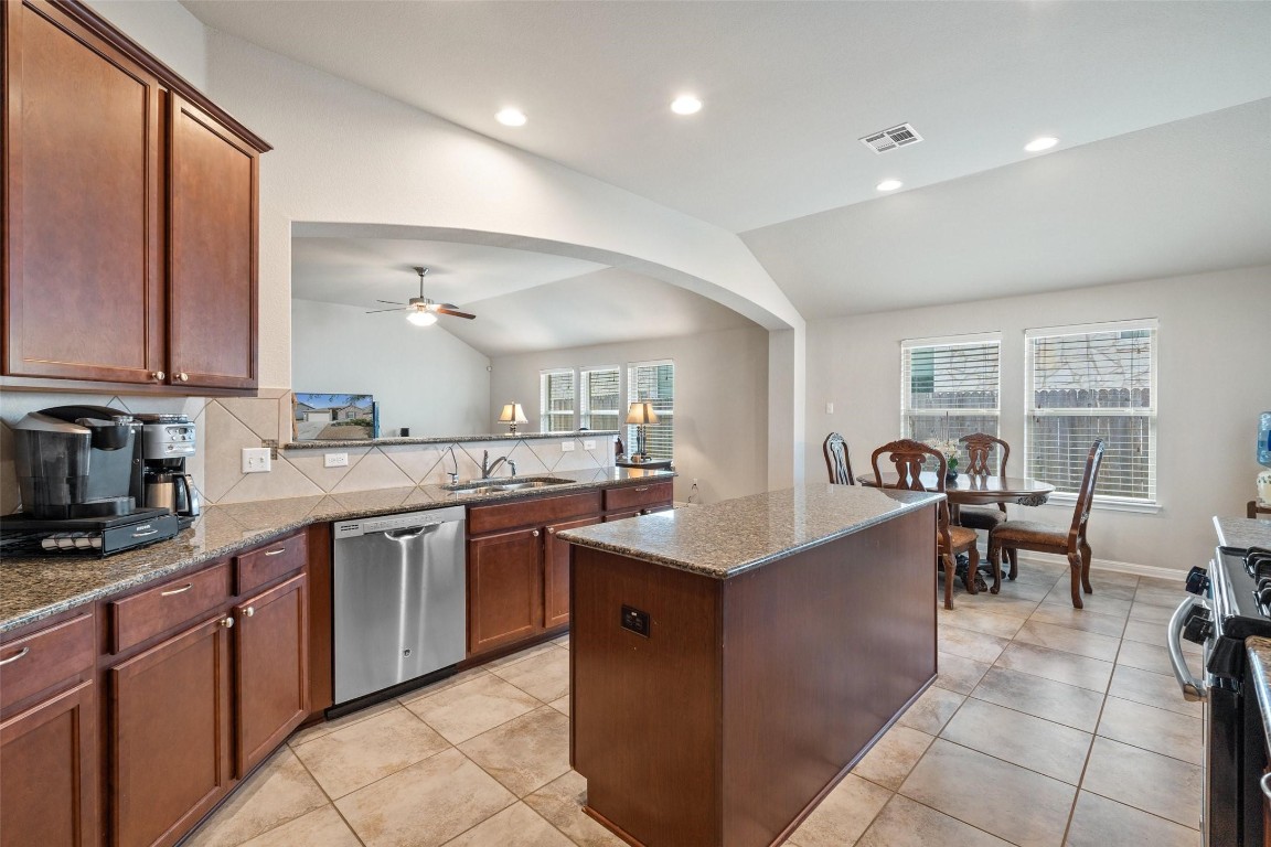 a kitchen with stainless steel appliances granite countertop a sink counter space and a window
