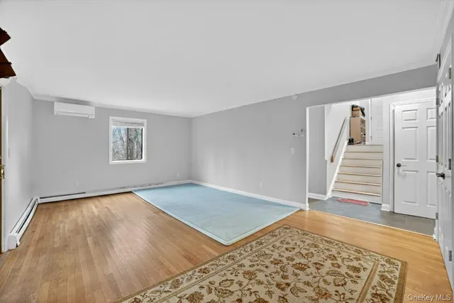 a view of a room with wooden floor and white walls
