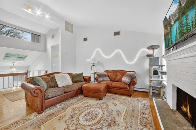 a living room with furniture a fireplace and a large window