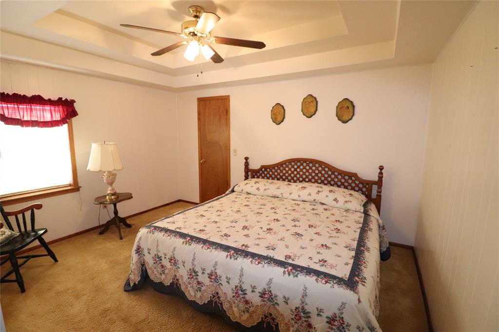 2553 Brixey Road Henrietta, TX 76365 - Photo 30 of 32 a bedroom with a bed and a chandelier