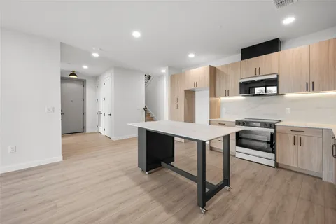 a kitchen with kitchen island a sink cabinets and wooden floor