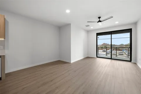 an empty room with wooden floor and windows with balcony