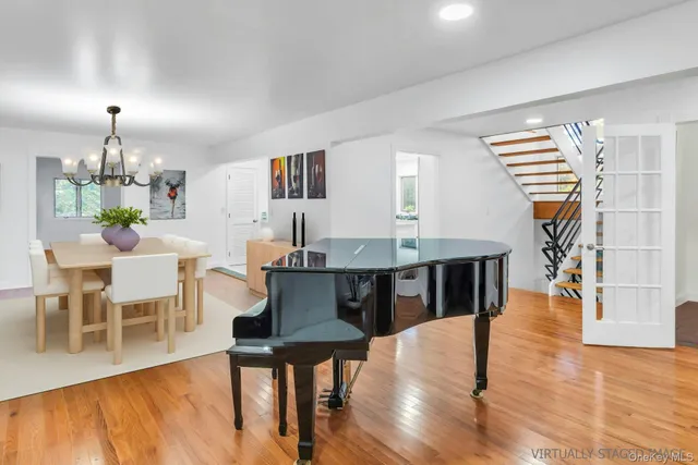 a dining room with furniture wooden floor a rug and a chandelier