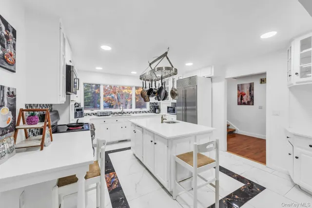 a living room with stainless steel appliances furniture and a view of kitchen