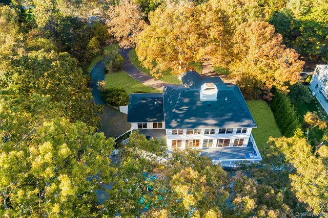 an aerial view of a house with a yard and lake view