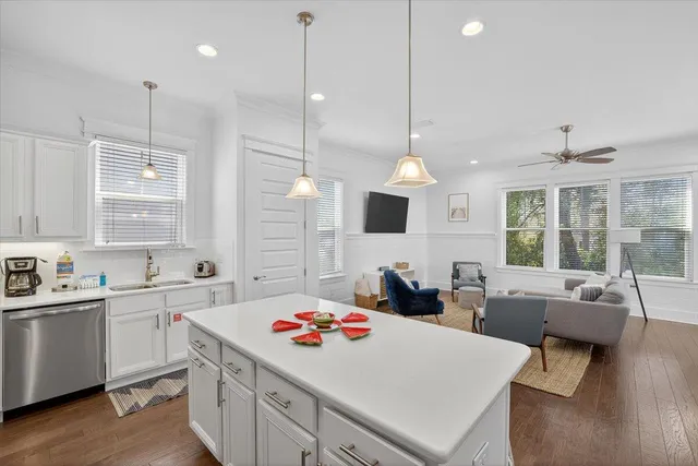 a kitchen that has a lot of cabinets and wooden floor