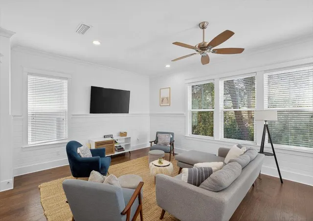 a living room with furniture a flat screen tv and a large window