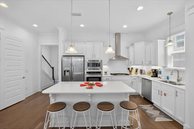 a kitchen with a dining table chairs sink and white cabinets