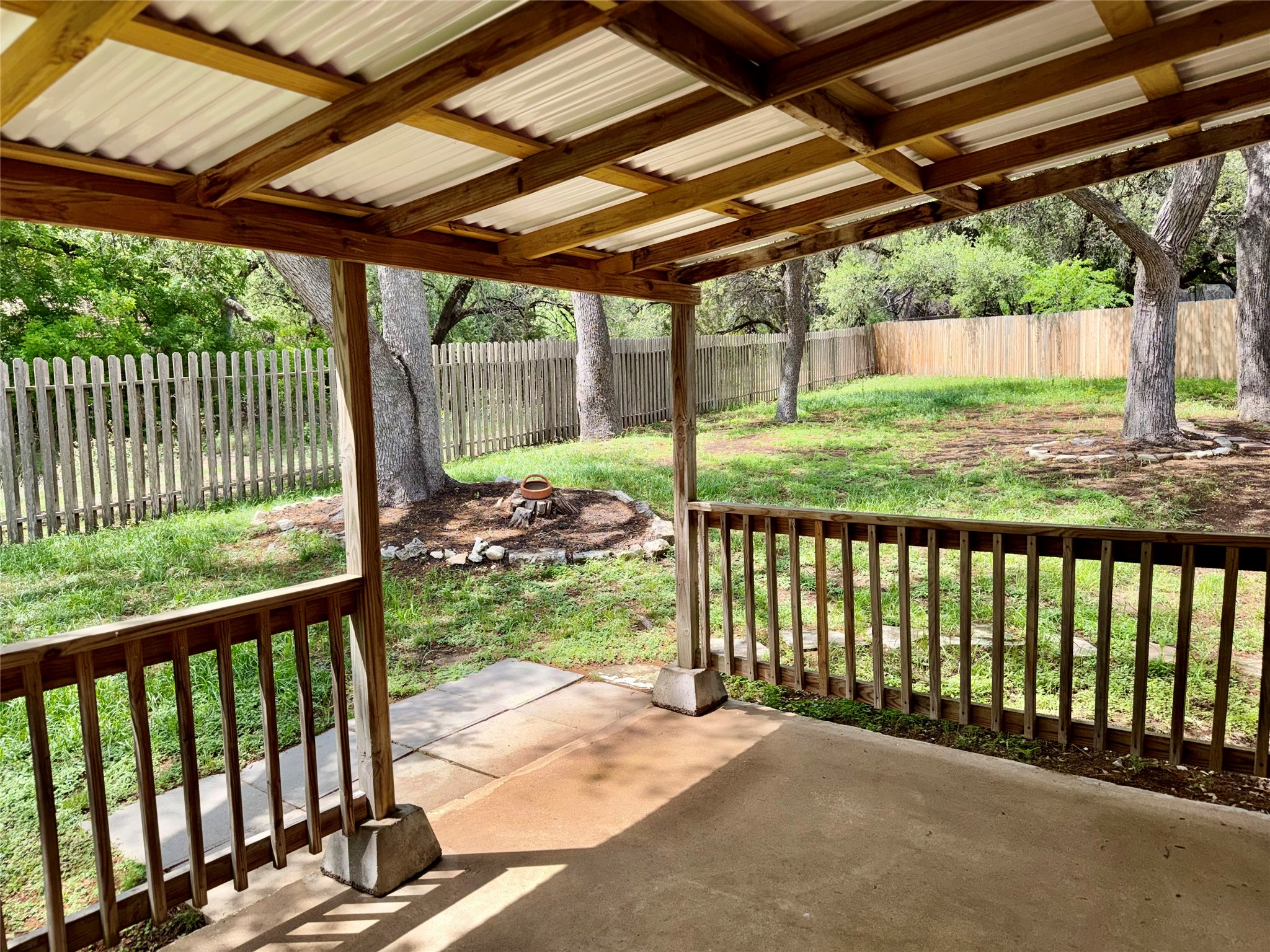 349 Fantail Loop, Unit B Austin, TX 78734 - Photo 1 of 9 Covered patio with a concrete surface, wooden railing, and a corrugated roof