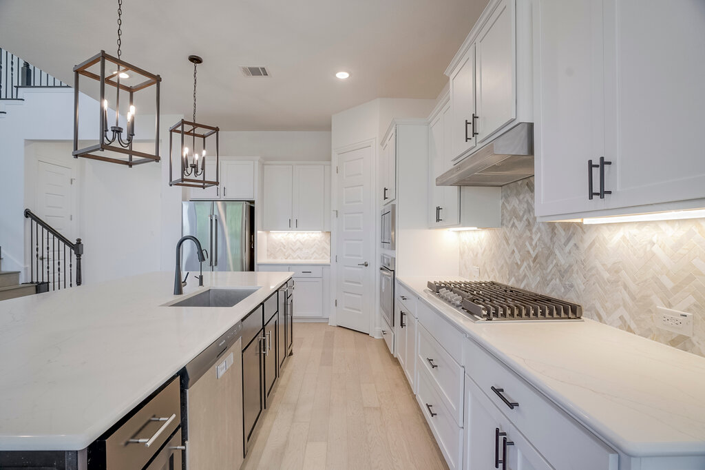 2920 Hadley Way Leander, TX 78641 - Photo 7 of 20 Culinary creations come to life in this kitchen, boasting premium appliances and a chic tile backsplash.