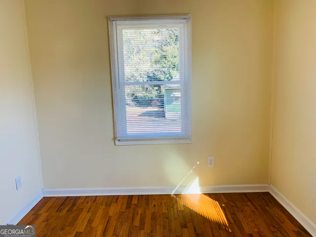 a view of a room with wooden floor and small window