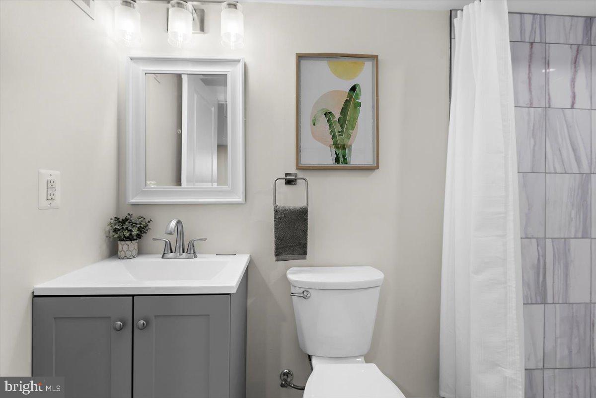 8303 Navahoe Drive Silver Spring, MD 20903 - Photo 31 of 39 a bathroom with a toilet sink and mirror