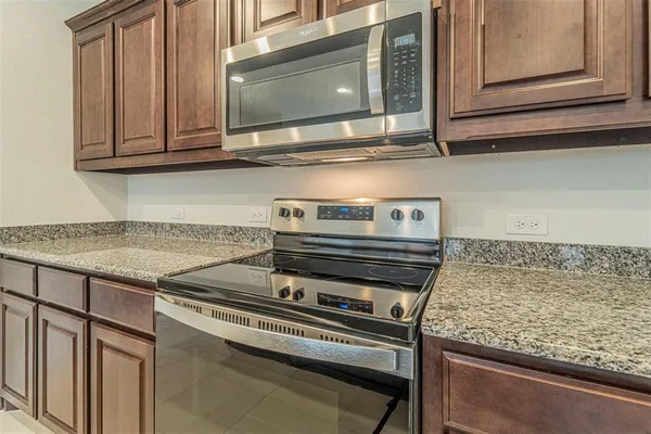 a kitchen with stainless steel appliances granite countertop a sink dishwasher stove and oven