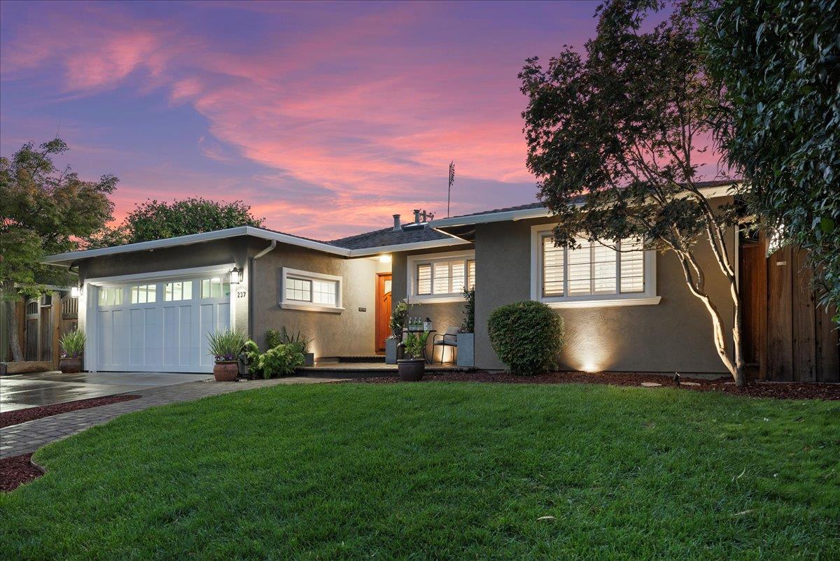 a front view of a house with a garden and yard