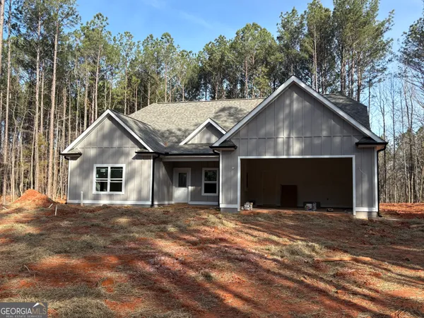 a view of a house with a yard and large tree
