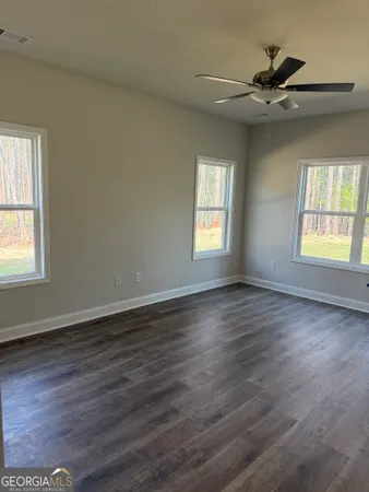 an empty room with wooden floor and windows