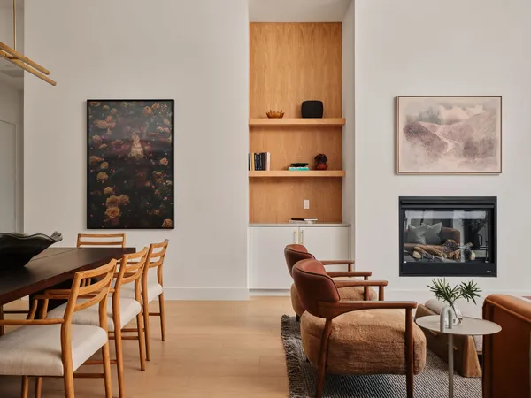 a living room with furniture a wall paintings and a lamp