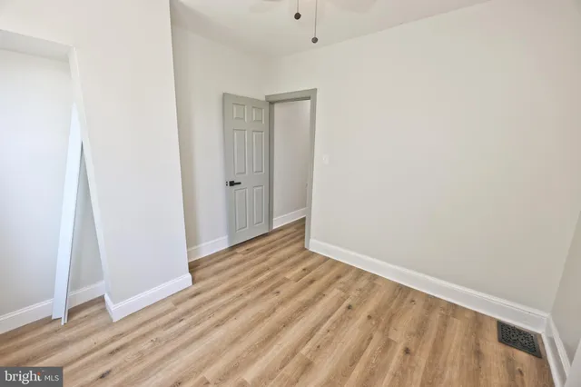 an empty room with a window and wooden floor